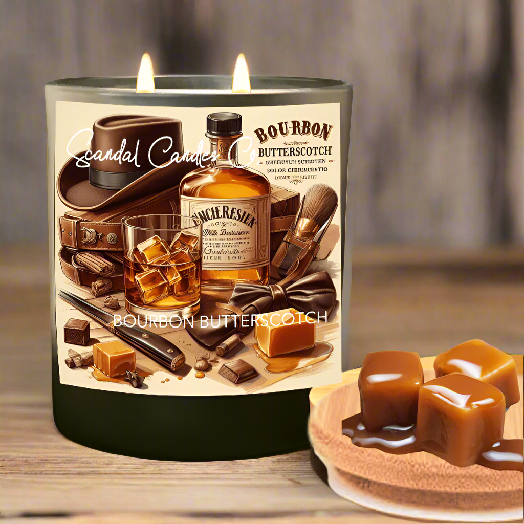 A two-wick candle in a glass jar with a label that reads 'Bourbon Butterscotch' and shows images of bourbon whiskey and butterscotch pieces. A small dish with butterscotch pieces is also visible in the foreground.