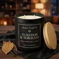 Open Tuxedos & Tobacco candle showing two unlit wicks, wooden lid beside the jar with satin, tobacco leaf and vanilla.