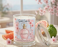 Happy candle with refreshed floral label styled with grapefruit, bergamot and blossoms