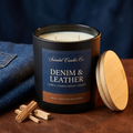 Open Denim & Leather candle showing two unlit wicks, with its wooden lid beside the jar and denim, leather and sandalwood accents.