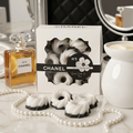 Black and white mini bundt wax melts styled with pearls, perfume bottle and wax warmer in a monochrome vanity setting